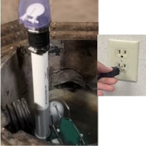 Pictured is the action of screwing connecting the dangling discharge pipe with the new check valve to thedischarge pipe from the sump pump in the pit; then plugging  the pump cord into the wall socket.